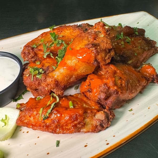 Chilangos Restaurant's spicy chicken wings with cilantro and a side of ranch dressing.